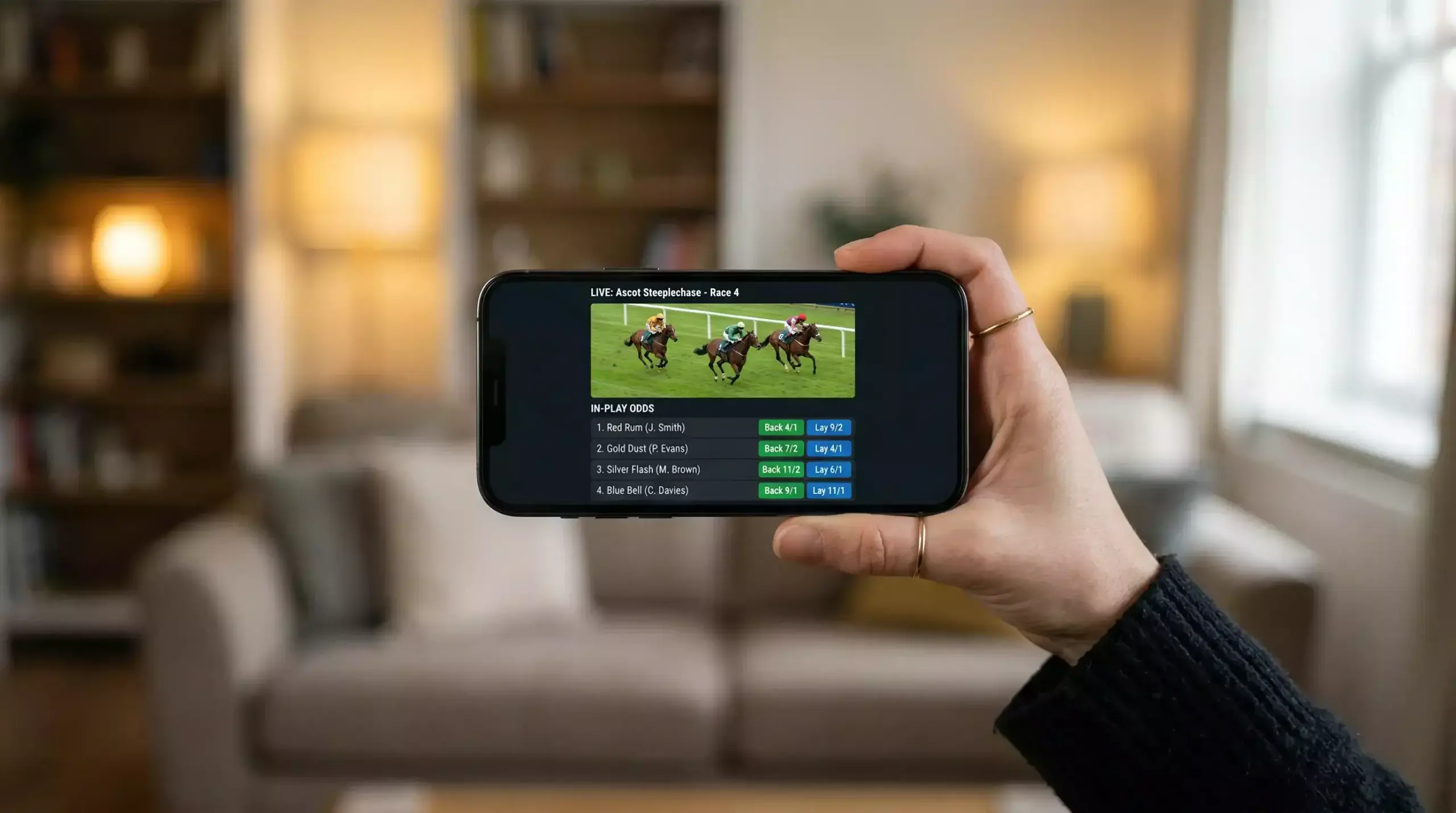 Mobile phone displaying a live horse racing stream from a UK bookmaker app